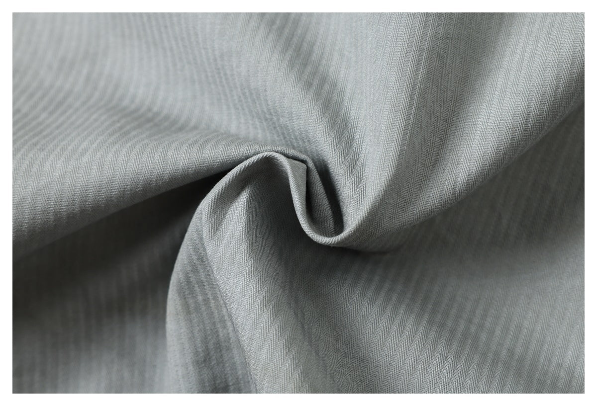 Close-up of gray fabric draped into a fold, showing its fine diagonal texture.