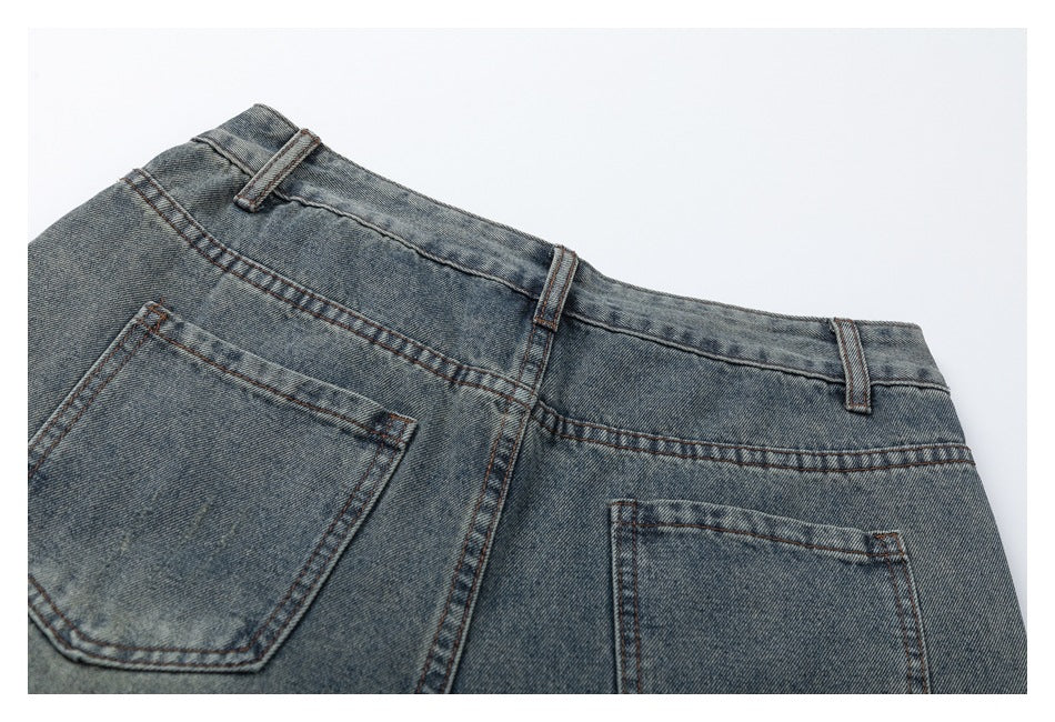 Partial back view of faded blue-gray jeans showing the waistband, belt loops, center seam, and back pockets.