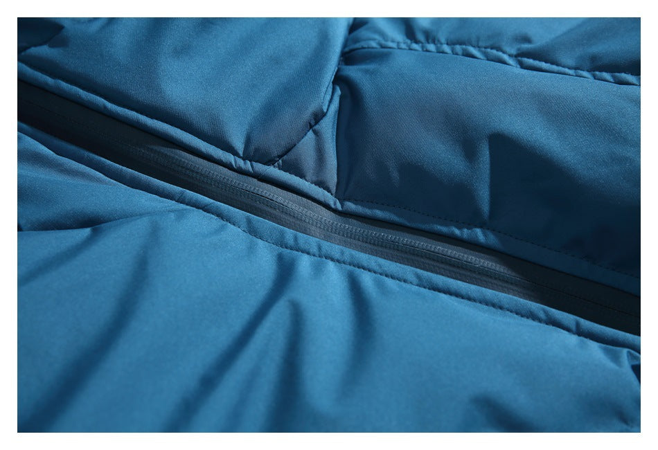 Close-up of a black zipper running across the teal-blue jacket fabric.