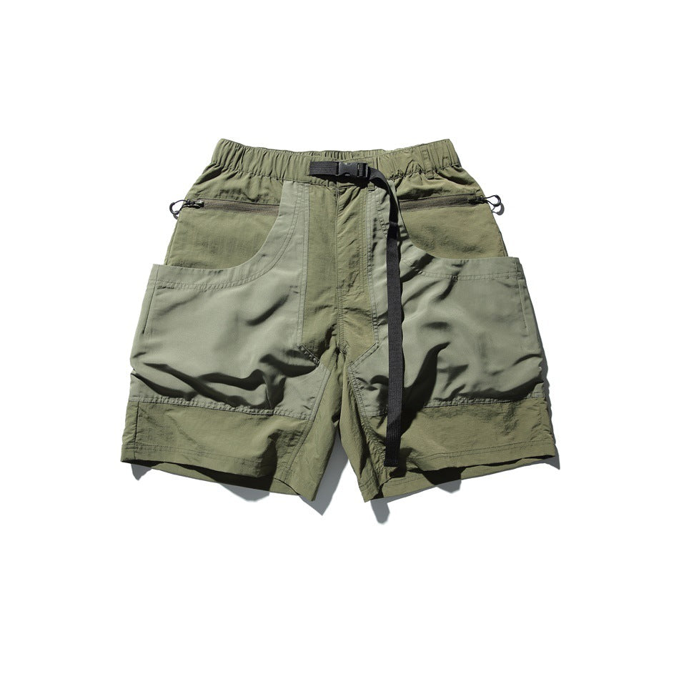 Olive green utility shorts with an elastic waistband, black webbing belt, zippered pockets, and large patch pockets.