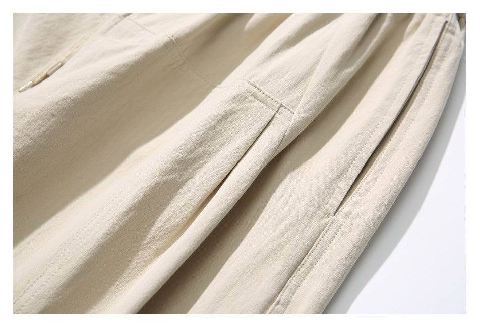 Close-up of beige pants showing a stitched side pocket and seam details.