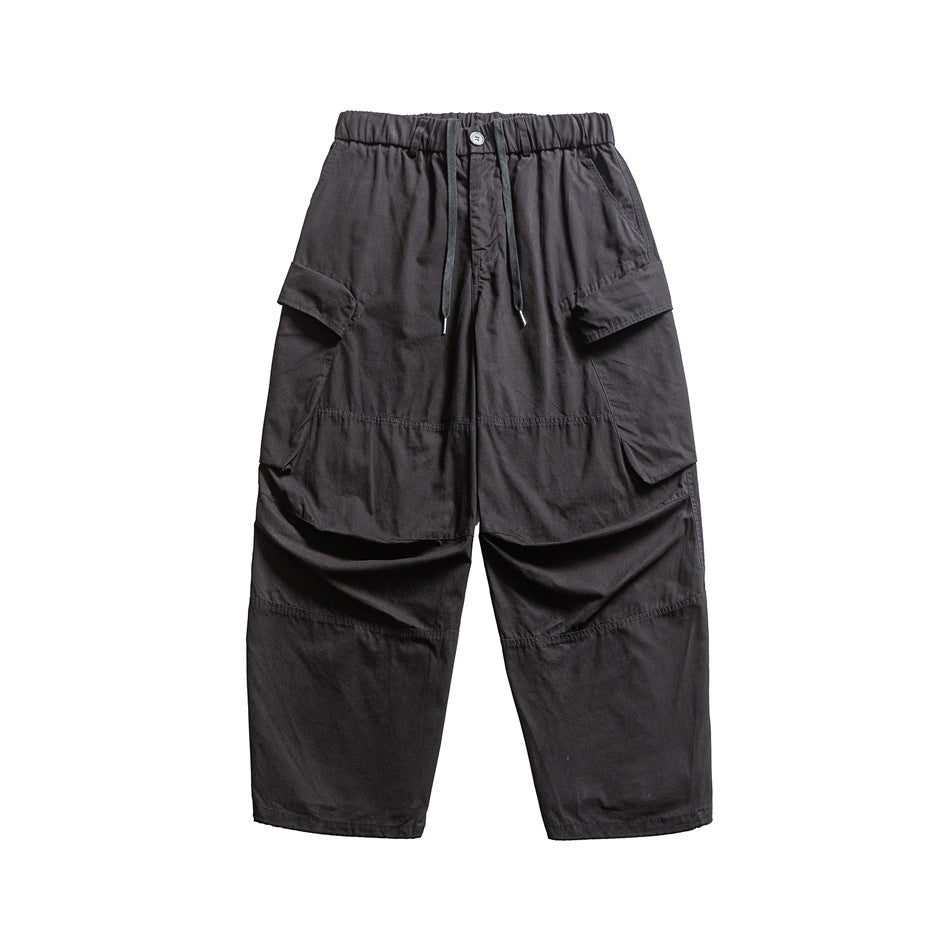 Black wide-leg cargo pants with elastic drawstring waist and large side flap pockets, flat front view