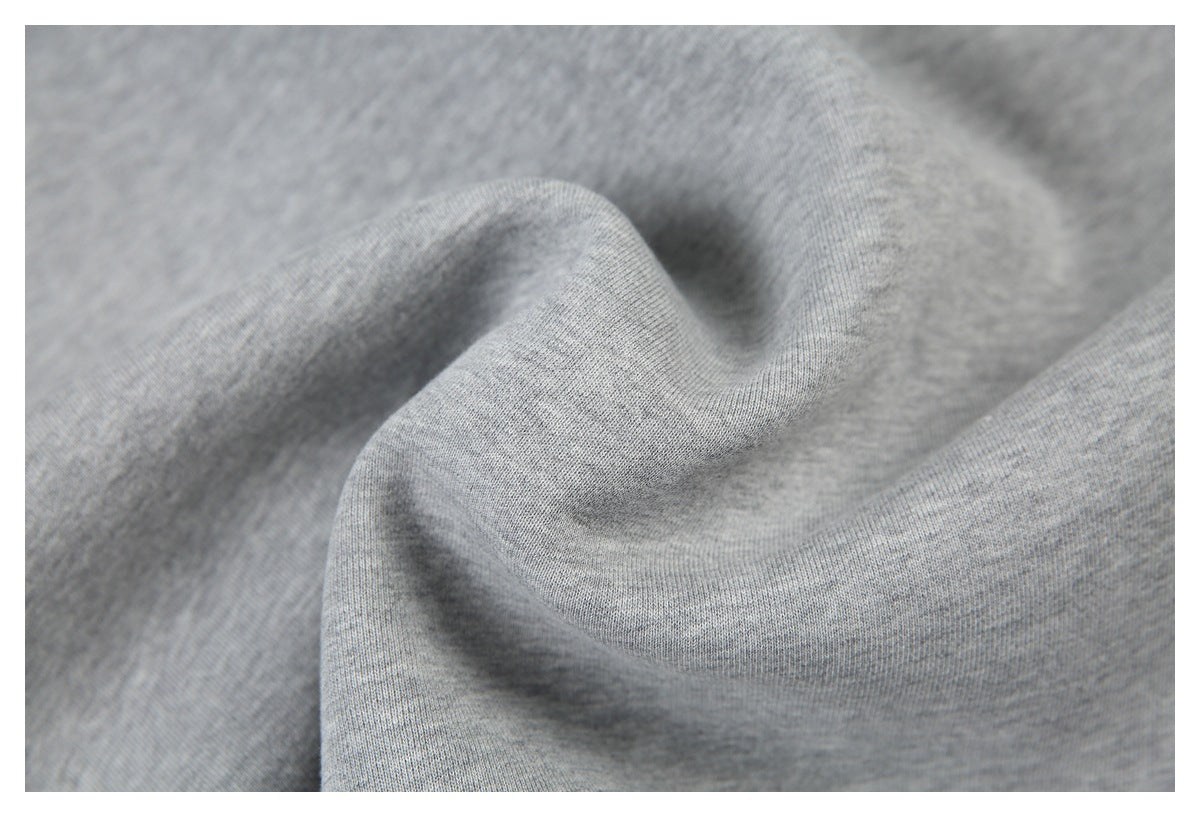 Extreme close-up of the heather gray sweatshirt fabric gathered into soft folds.
