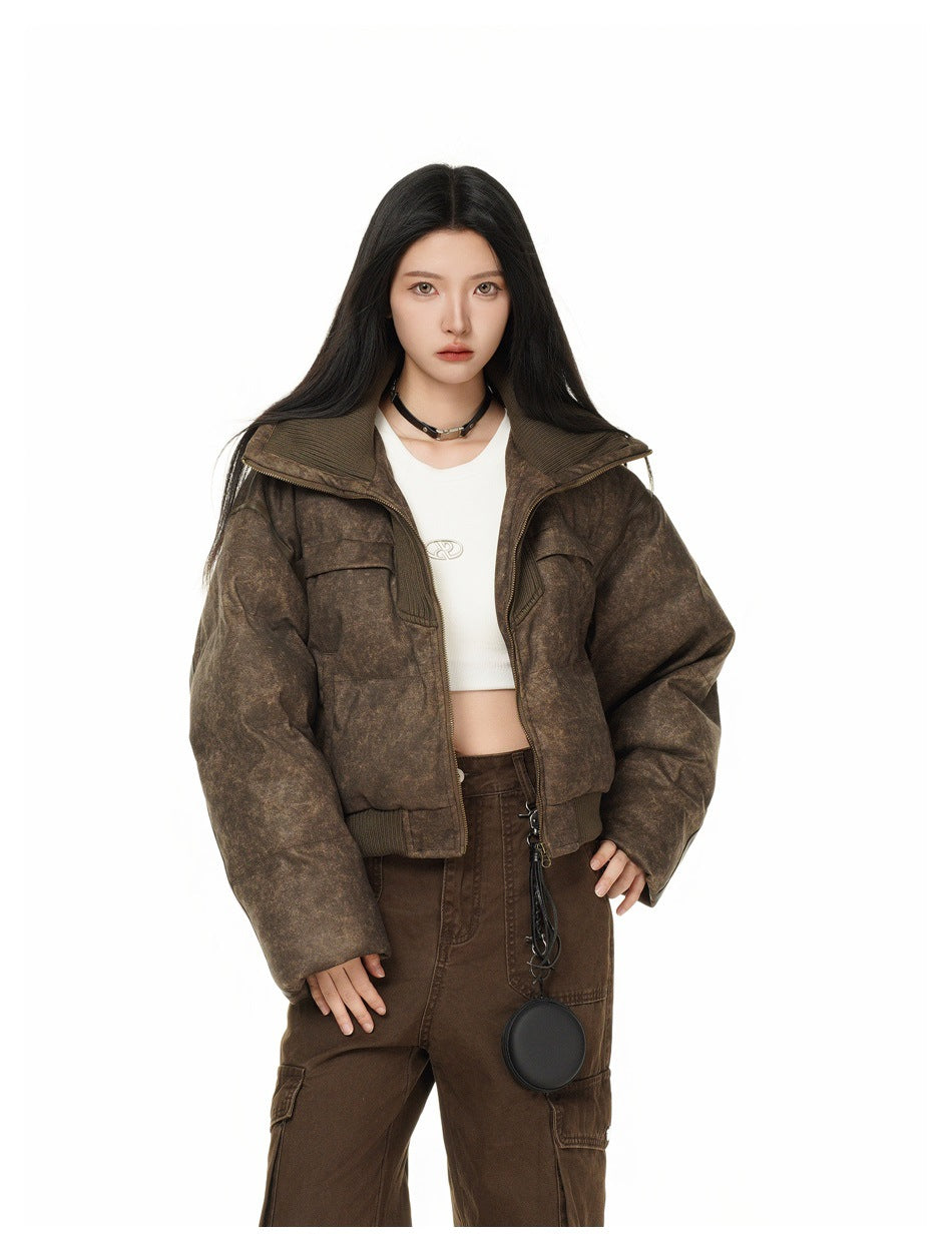 Closer front view of a model wearing a mottled brown cropped jacket over a white crop top and brown cargo pants.