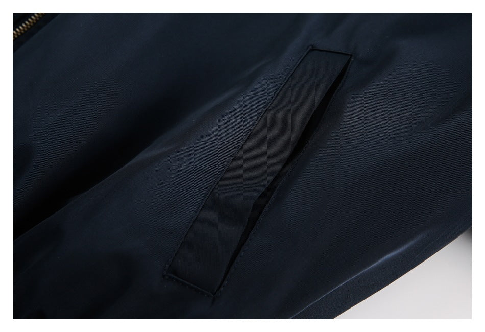 Close-up of a slanted welt pocket on a dark navy garment.
