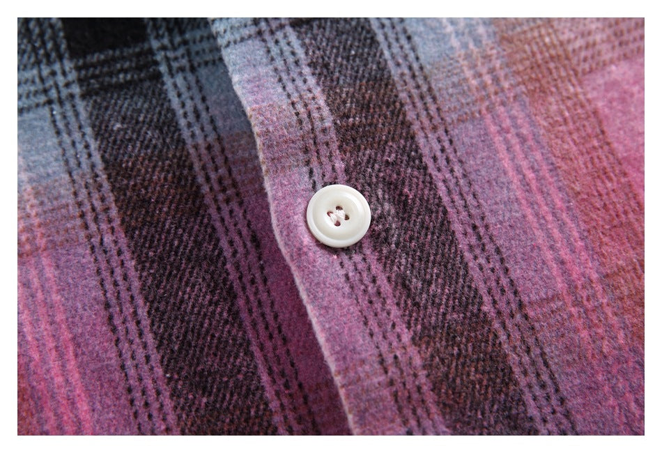 Close-up of a white button on pink and dark plaid fabric.