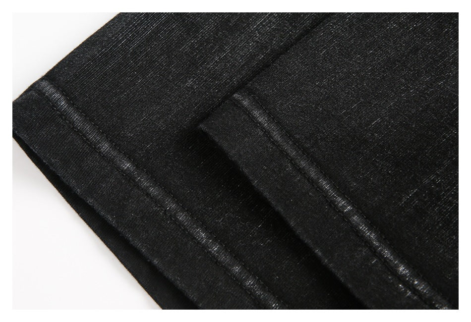Close-up of black garment fabric showing a folded edge and stitched seams.