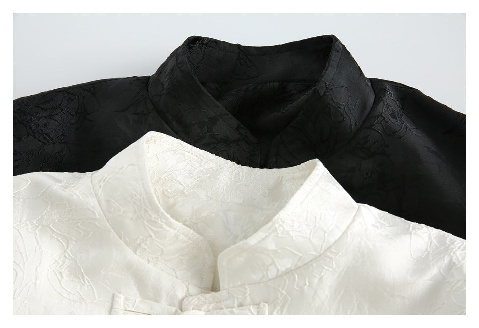 Close-up of black and ivory jackets showing their stand collars and raised floral patterns.