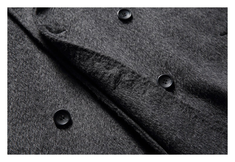 Close-up of the charcoal gray coat's overlapping front panels and black buttons.