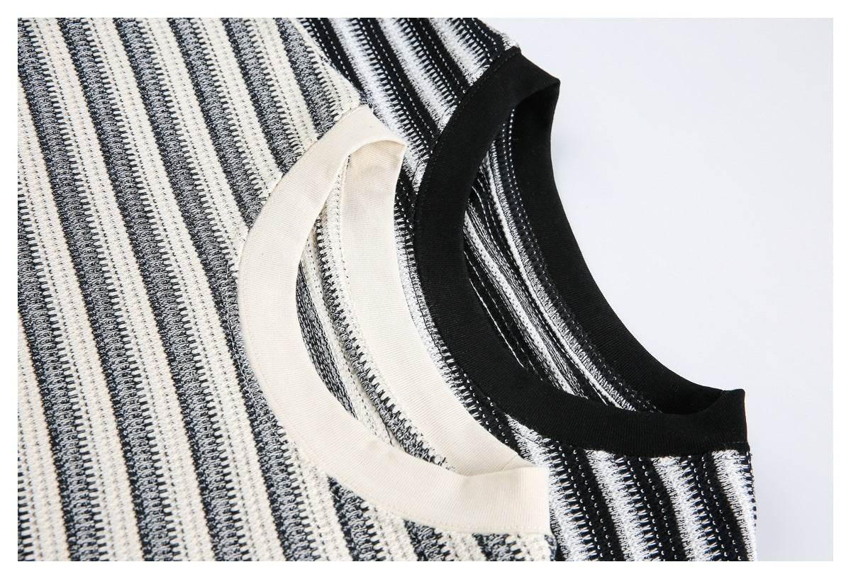Close-up of cream and black ribbed crew necklines on two striped shirts.