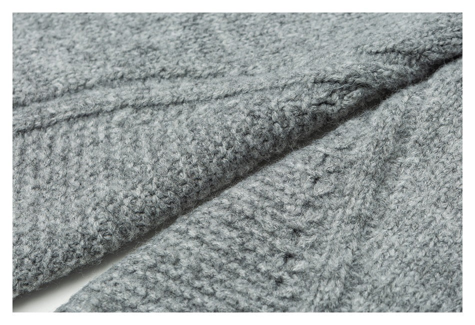 Close-up of light gray knit fabric folded to show its textured stitches and seam.