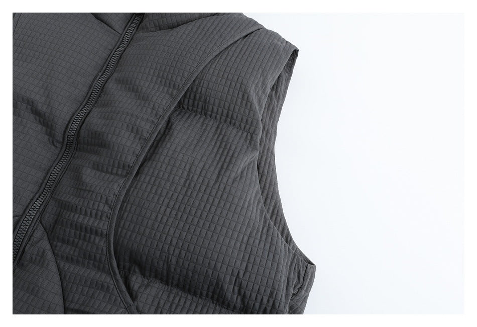 Close-up of the charcoal vest's quilted side panel and armhole edge.