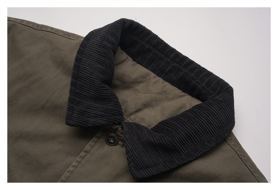 Close-up of an olive-brown jacket with a wide black ribbed collar and a dark button.