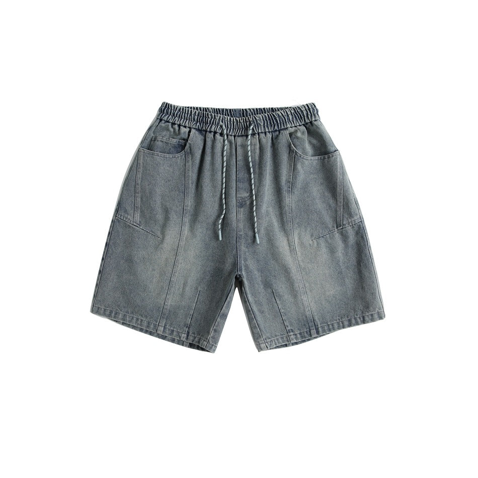 Faded blue washed denim-look shorts with elastic drawstring waist and large front patch pockets, front flat lay