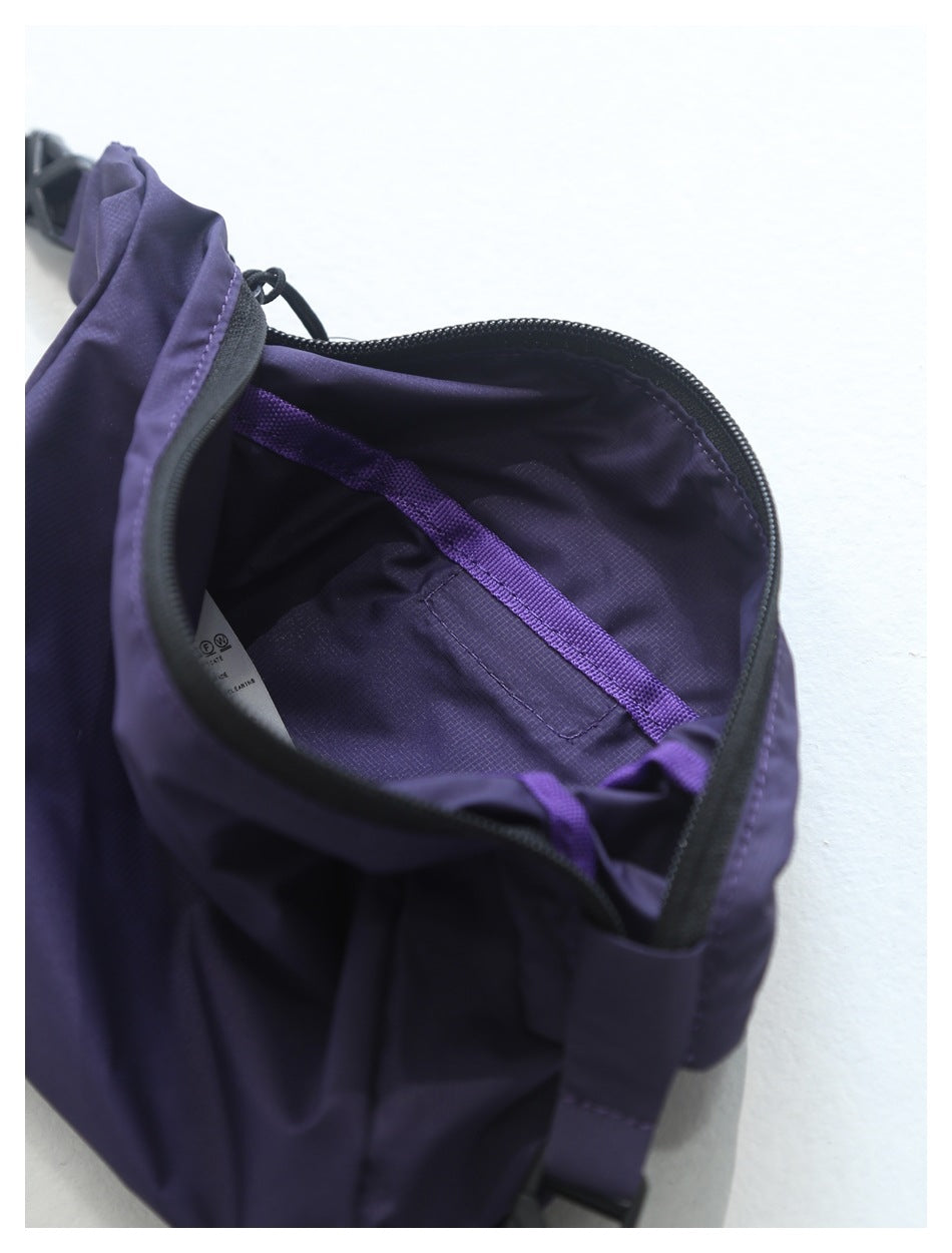 Close-up of the purple bag's open interior, showing a zipper, lining, and internal strap.