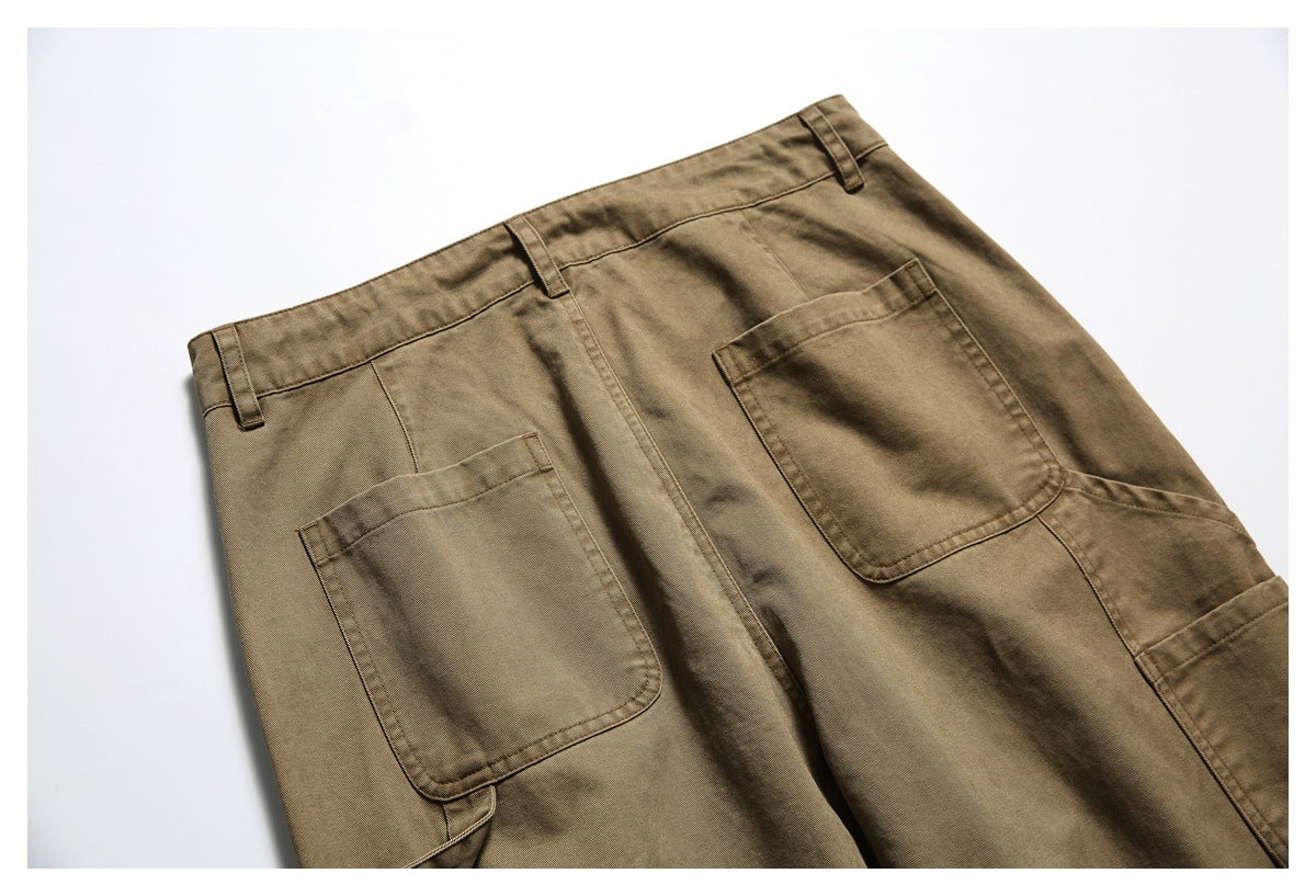 Close view of the back of brown work pants, showing the waistband, belt loops and two large patch pockets.