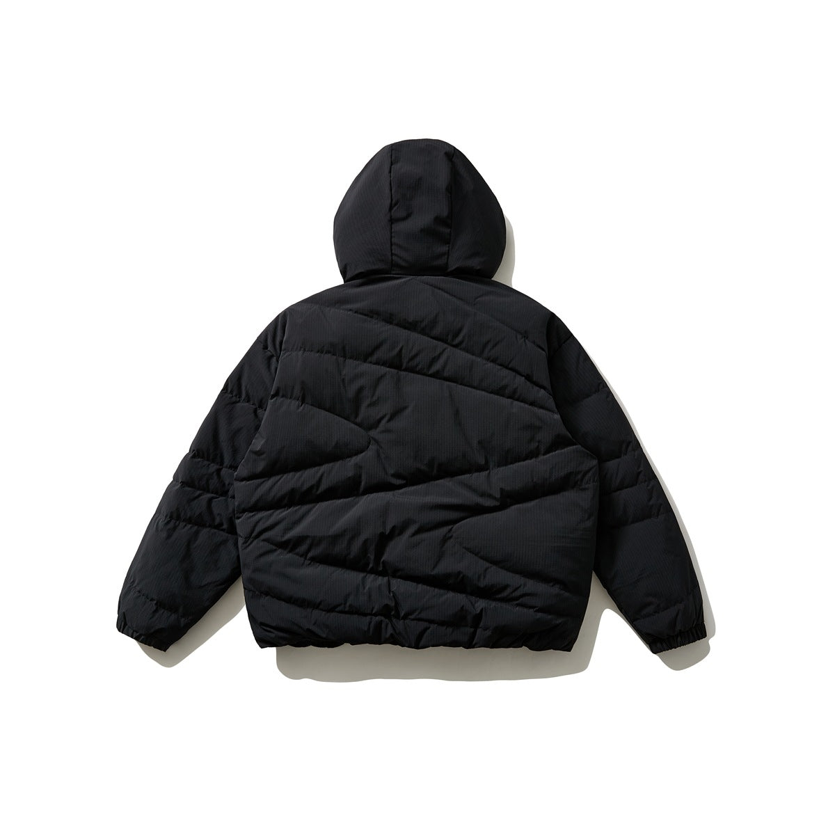 Back view of a black hooded quilted jacket with diagonal paneling and elastic cuffs.
