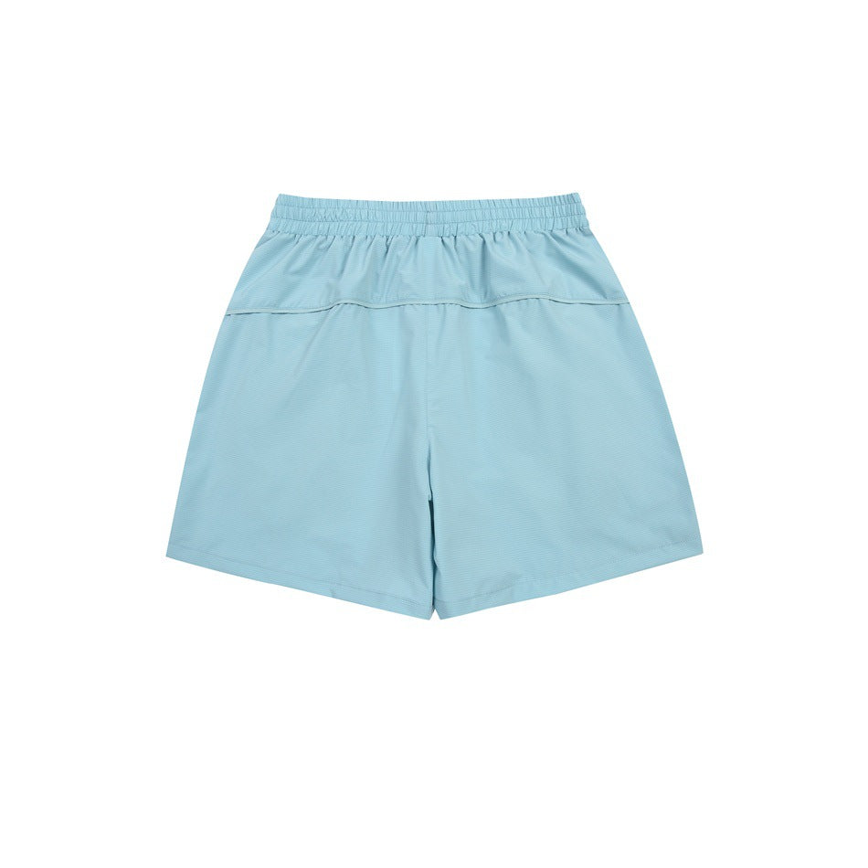 Pale blue athletic shorts, back view, with an elastic waistband and horizontal yoke seam.