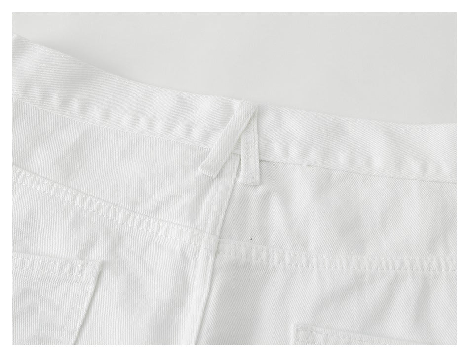 Close-up of the back waistband, belt loops, and stitching on white trousers.