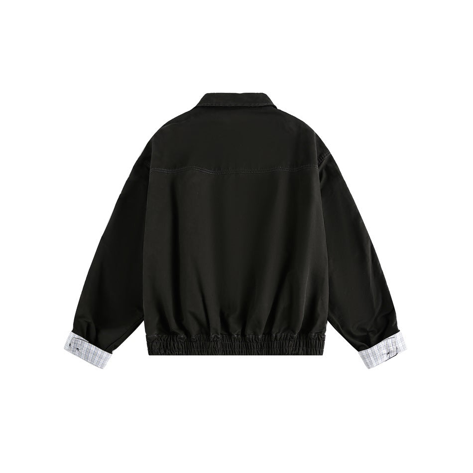 Back view of a black jacket with a pointed collar, gathered elastic hem, and white checked lining visible at the turned-back