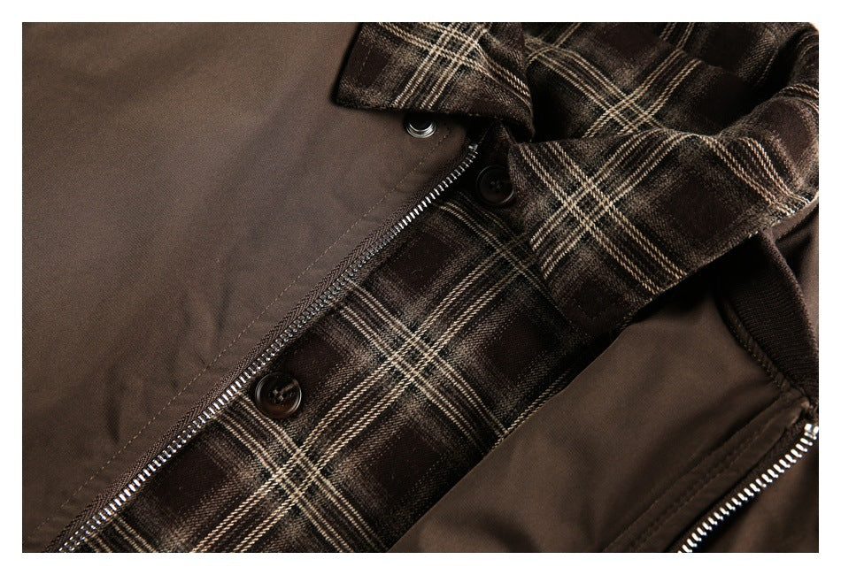 Close-up of a brown jacket's plaid front panel, buttons, and zipper closure.