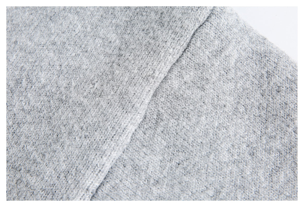 Close-up of light gray knit fabric and a diagonal stitched seam.