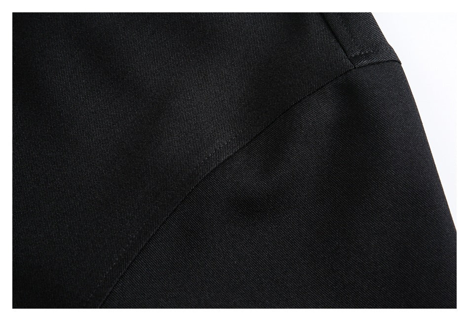 Close-up of black garment fabric and a curved stitched seam.