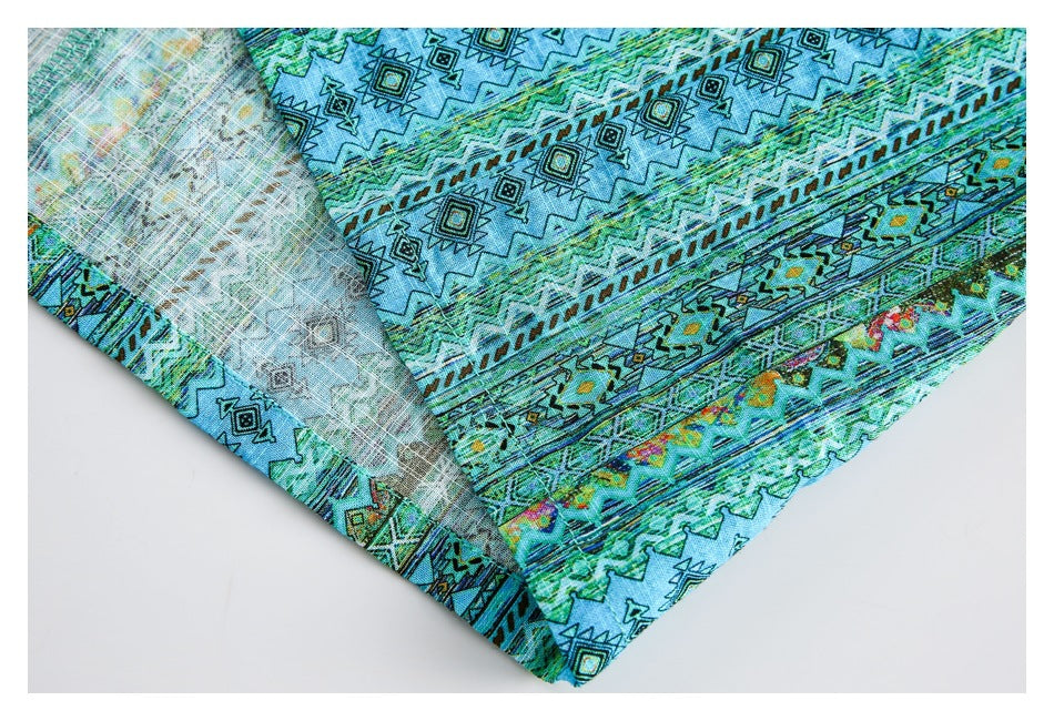 Close-up of turquoise fabric with geometric bands and a pale reverse side.