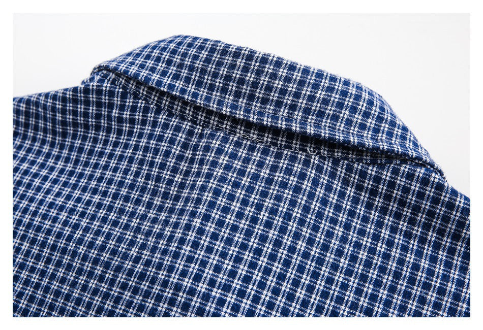 Close-up of the collar and checked fabric of a navy and white shirt.