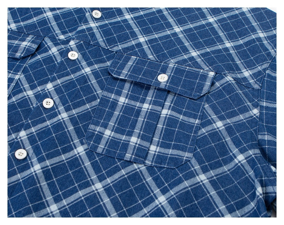 Close-up of the blue-and-white plaid shirt front, showing buttons and overlapping chest pockets.
