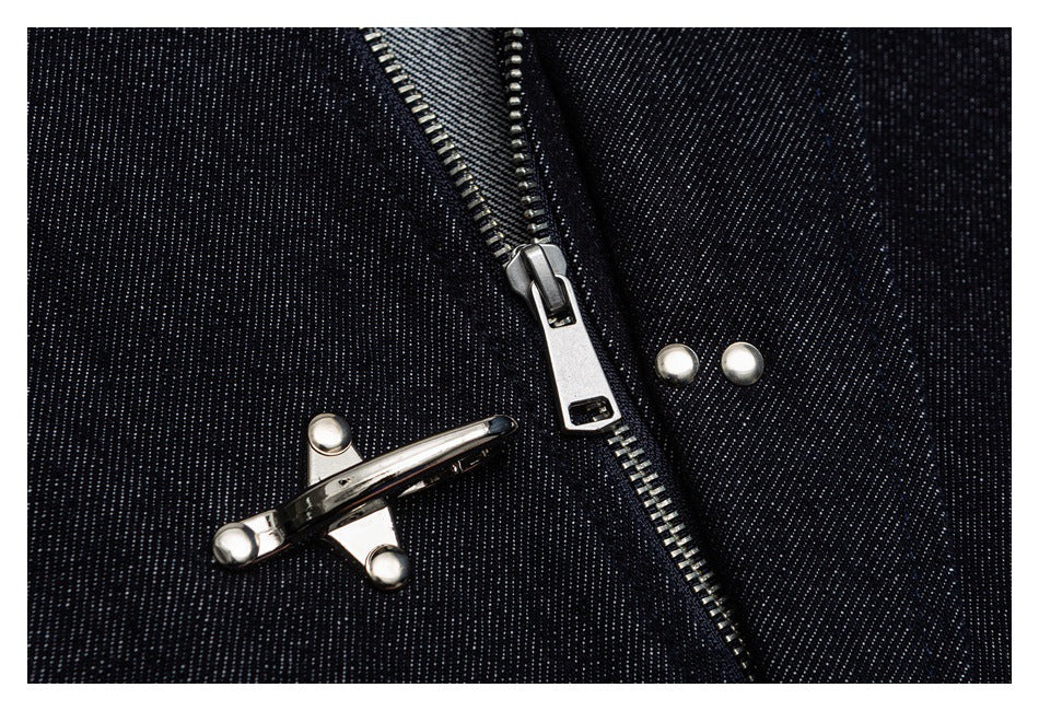 Close-up of dark denim with a silver zipper, metal clasp, and round studs.