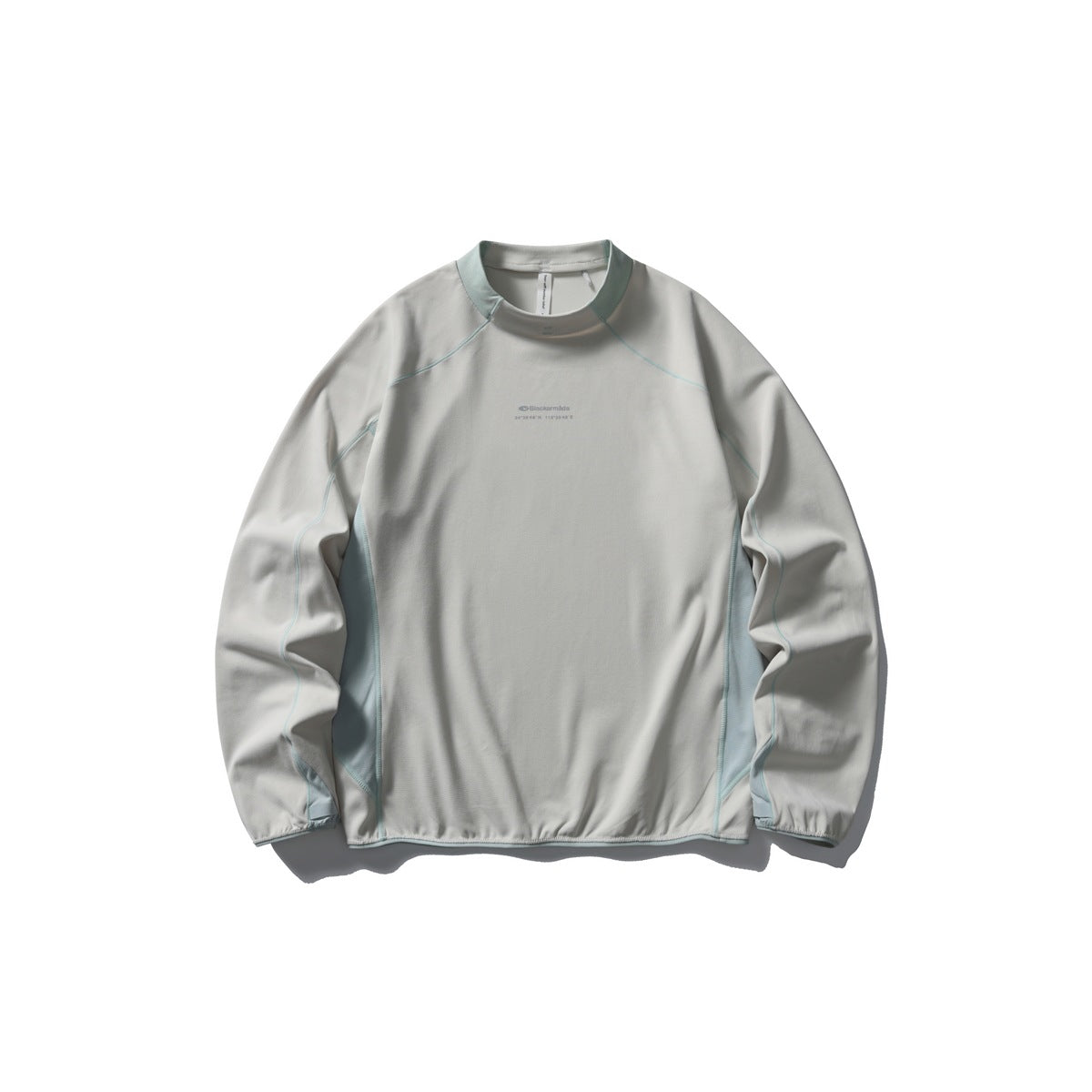 Off-white light gray long-sleeve mock neck top with pale blue-green collar trim, side panels and stitching, flat lay