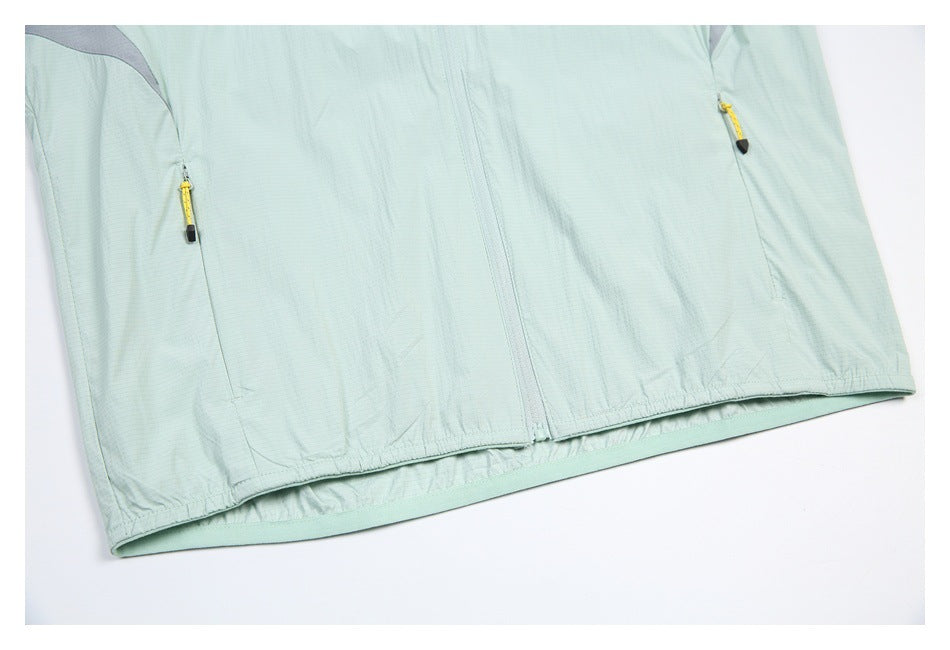 Cropped front view of a pale mint jacket showing the center zipper, two zip pockets, and gathered hem.