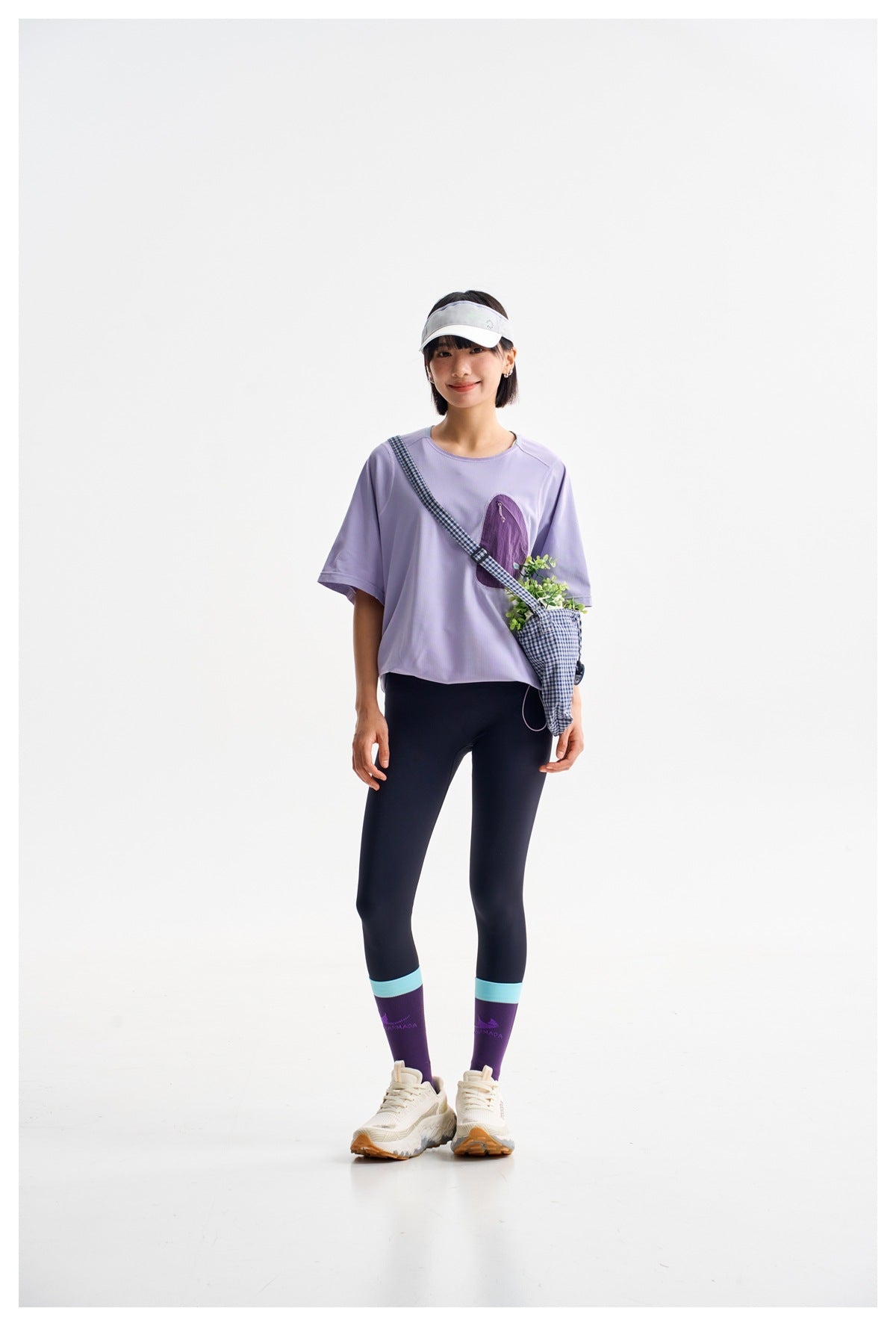Front view of a model wearing a lavender oversized tee with a purple chest pocket and dark leggings.