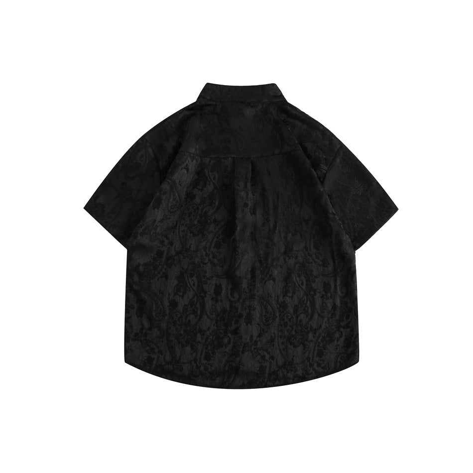 Back view of a black short-sleeve shirt with a stand collar, curved hem and tonal floral pattern.