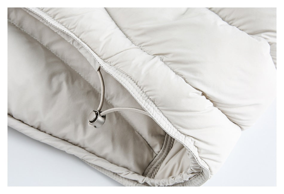 Close-up of the white padded jacket's edge and an adjustable cord with a metal toggle.