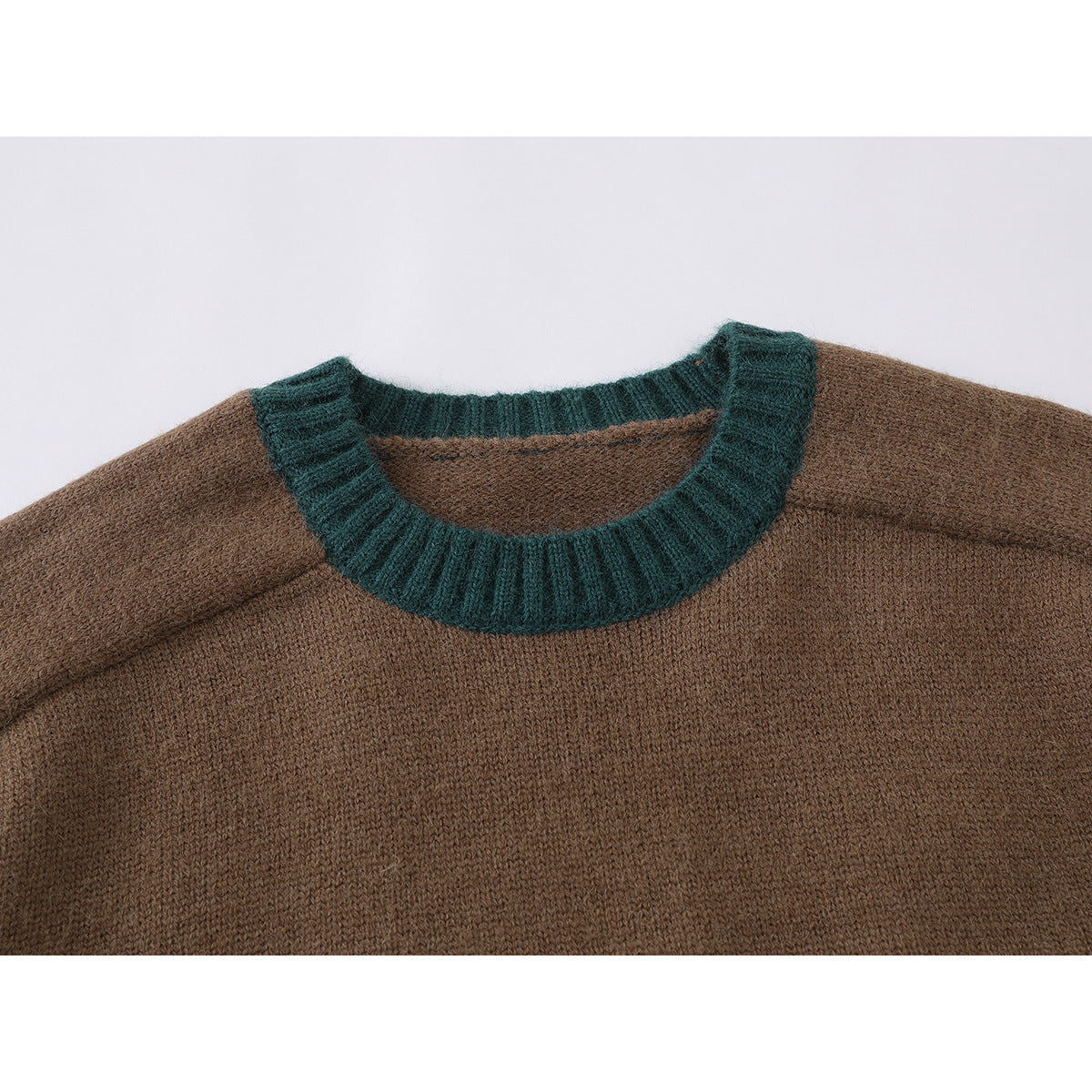 Close-up of a brown knit sweater with a dark teal ribbed crew neckline.