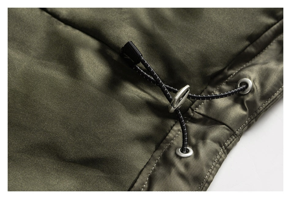 Close-up of an olive jacket's adjustable drawcord, metal eyelets, and cord lock.