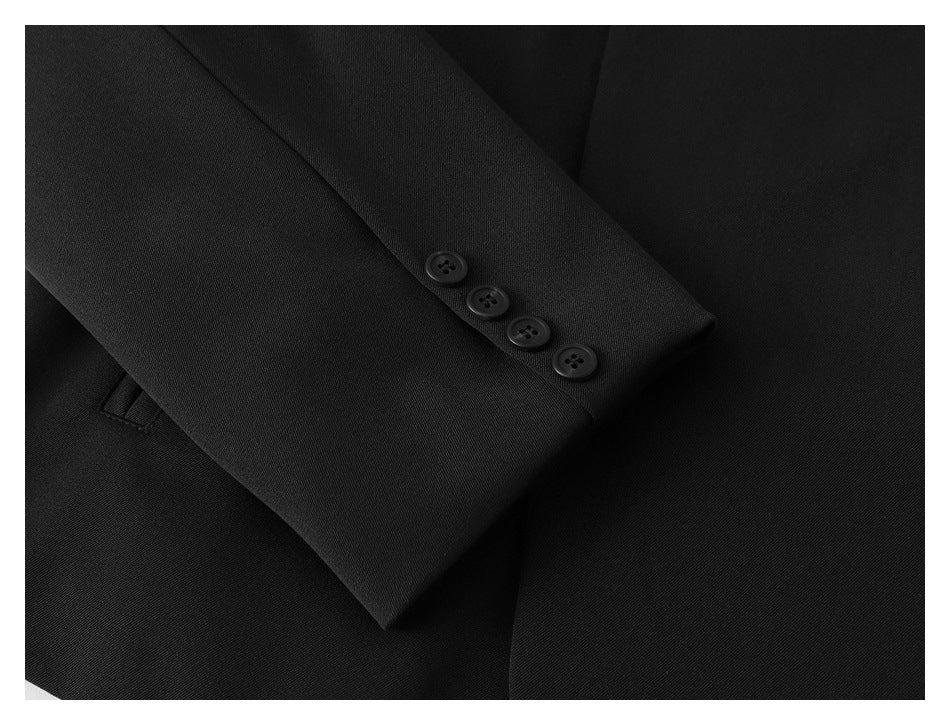 Close-up of a black jacket sleeve cuff with four buttons.