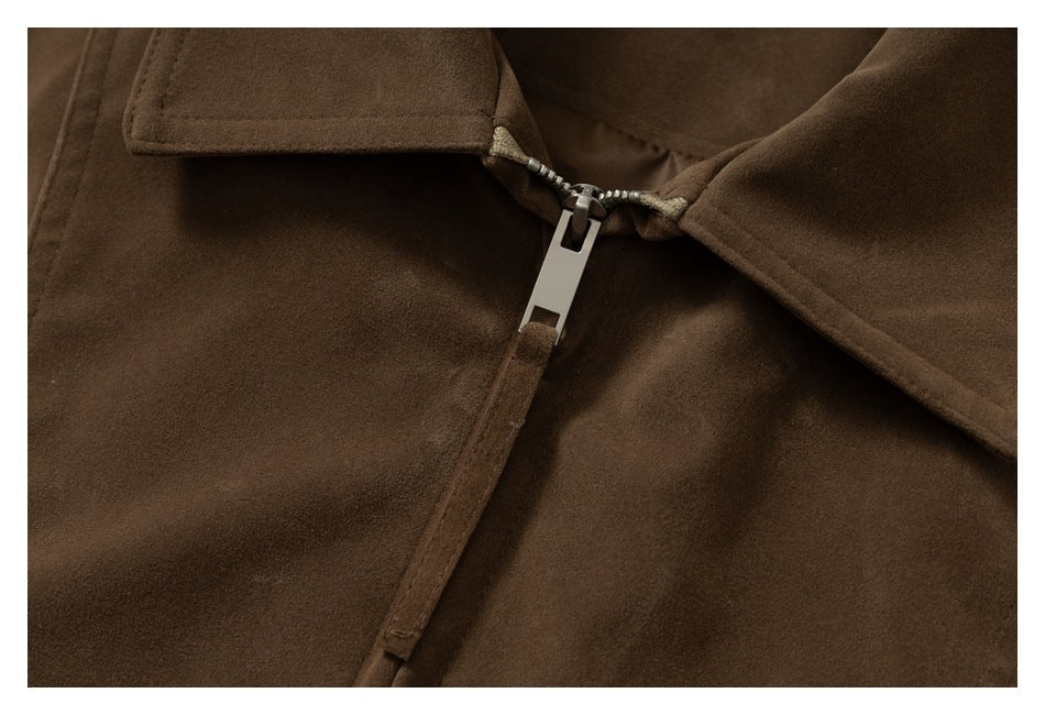 Close-up detail of the brown jacket's silver zipper and collar edges.