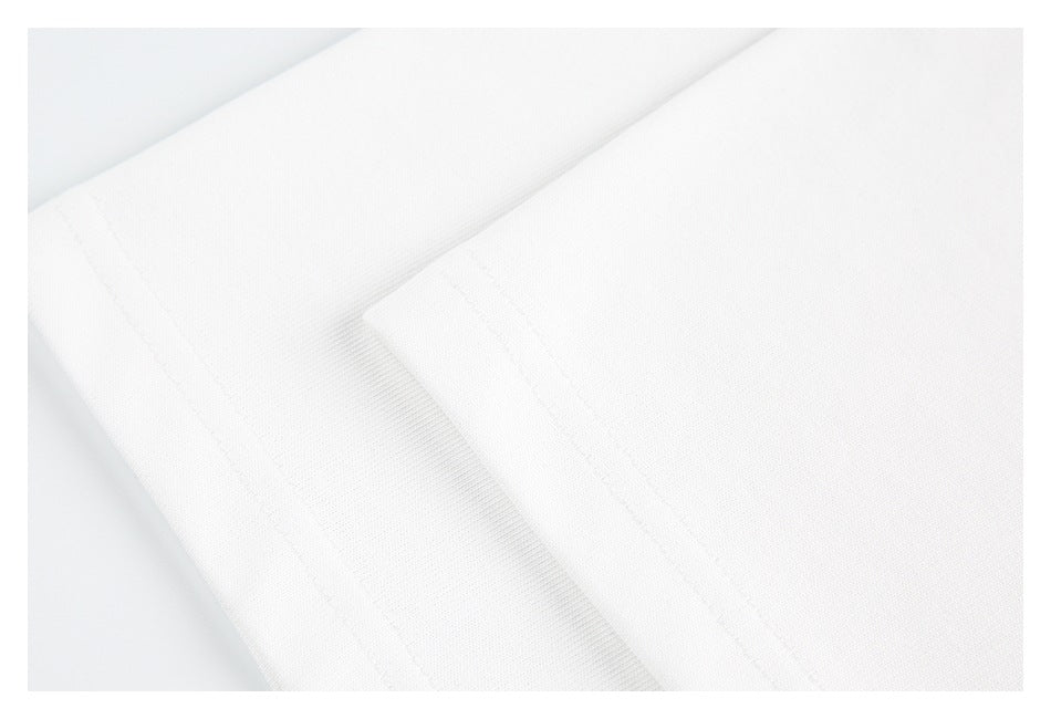 Close-up of a white garment's folded edge and parallel stitched seams.