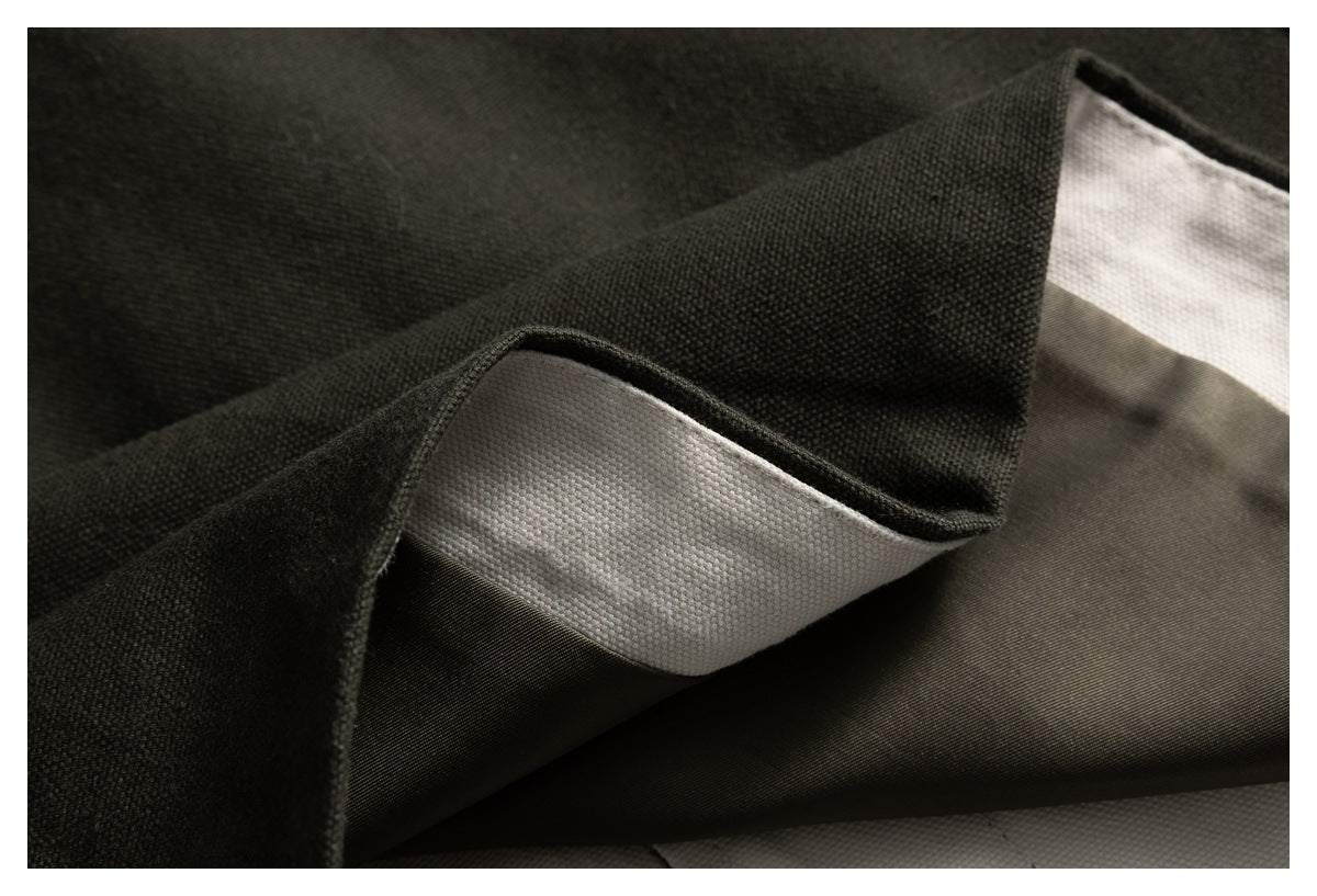 Close-up of folded dark fabric showing a pale inner layer and smooth darker underside.