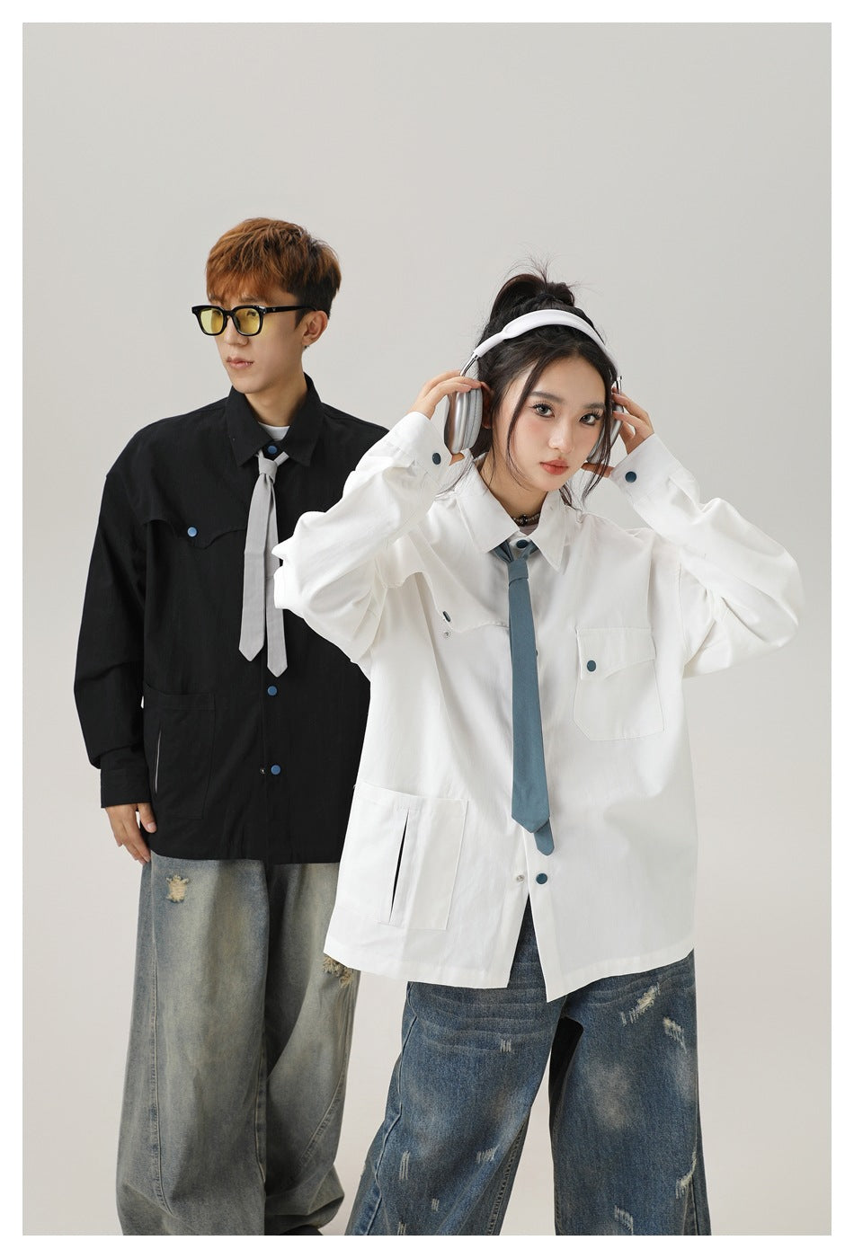 Two models pose in oversized black and white button-front shirts with chest pockets and contrasting ties.