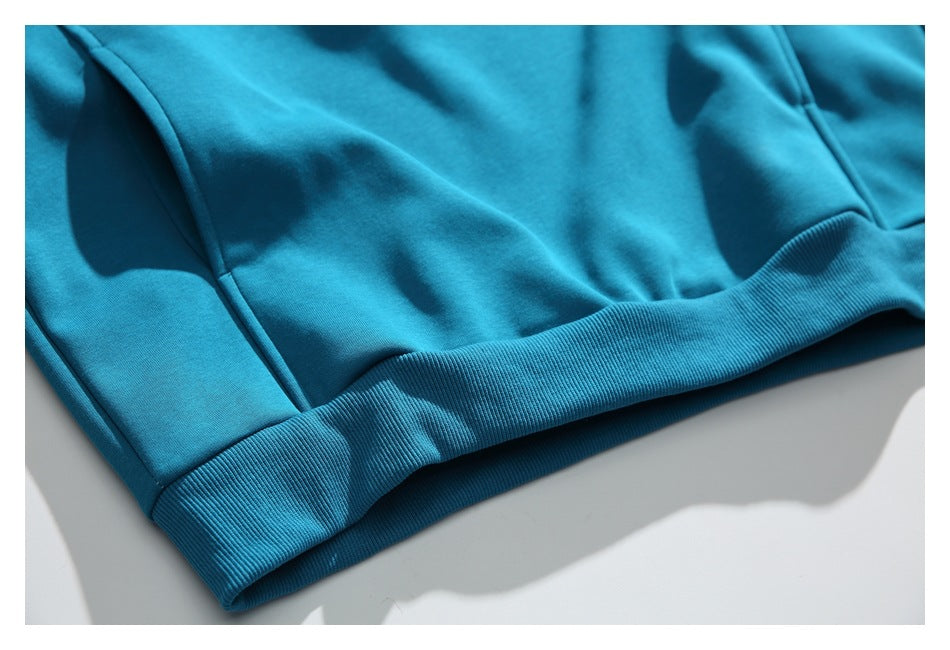 Close-up of the teal top’s wide ribbed hem and lower seam.