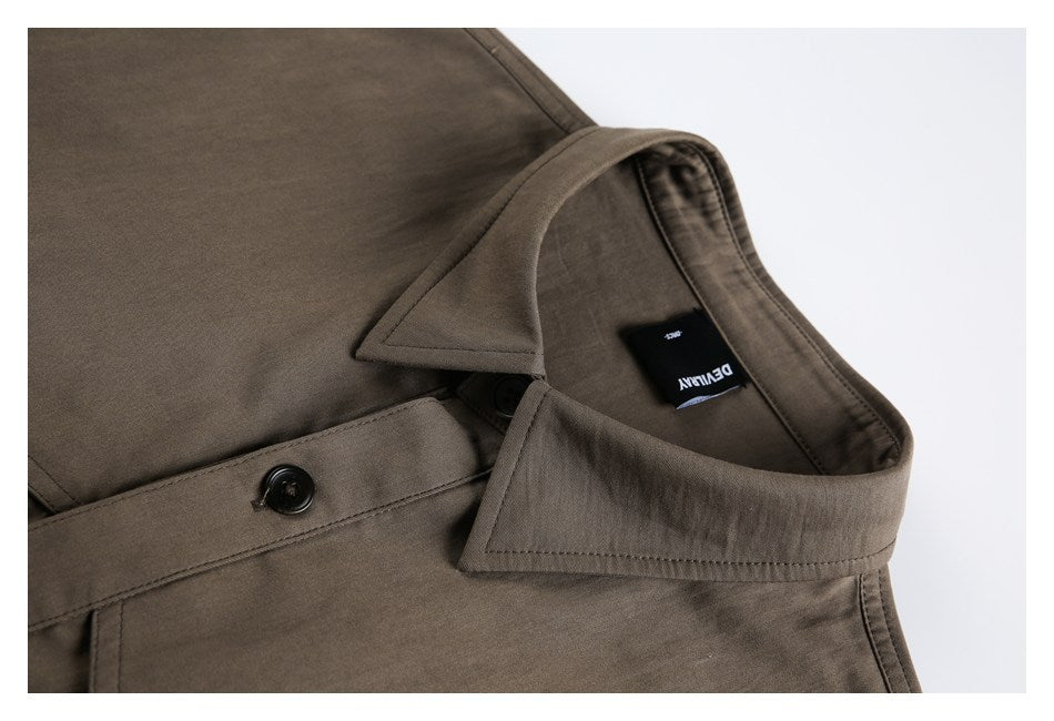 Close-up of a brown collared shirt with a black neck label and front button.