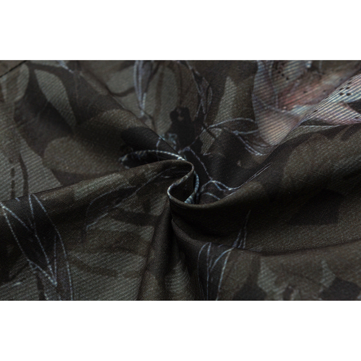Macro view of draped dark camouflage-print fabric with muted blue and pale accents.