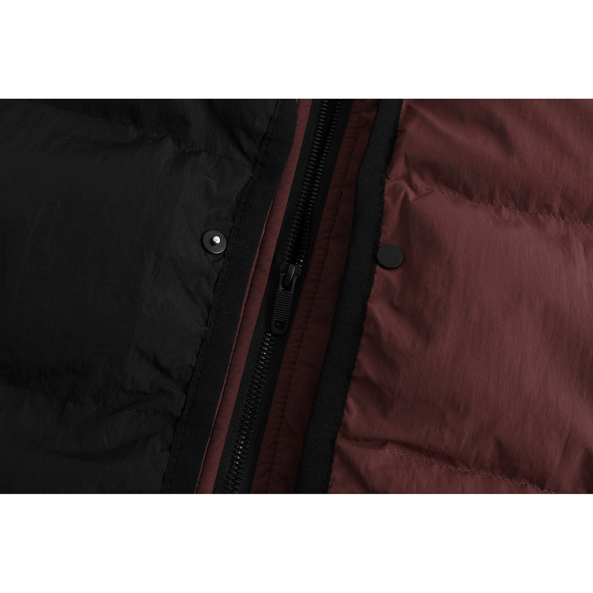Close-up of the jacket's black zipper and snap fasteners between black and burgundy quilted panels.