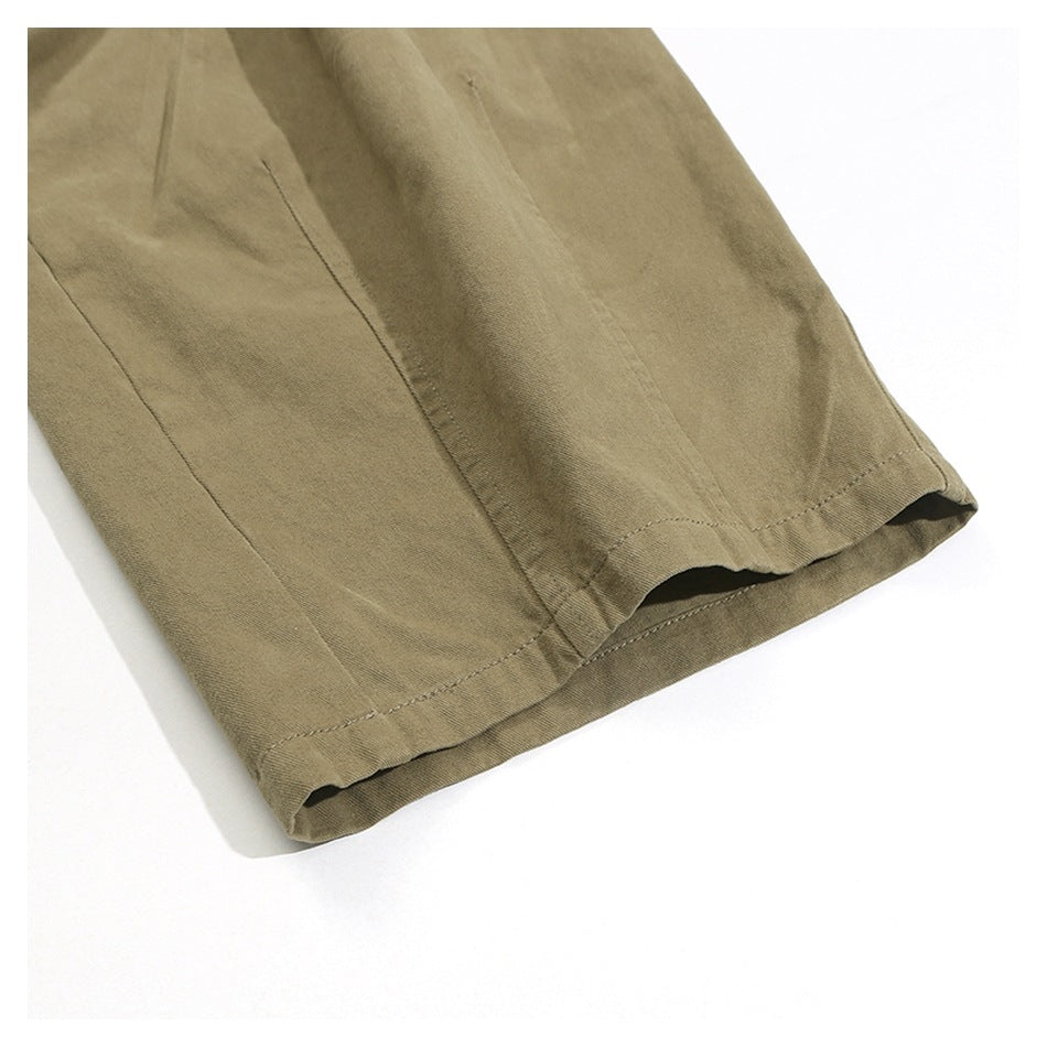 Close-up of a khaki trouser leg showing the stitched hem and open leg opening.
