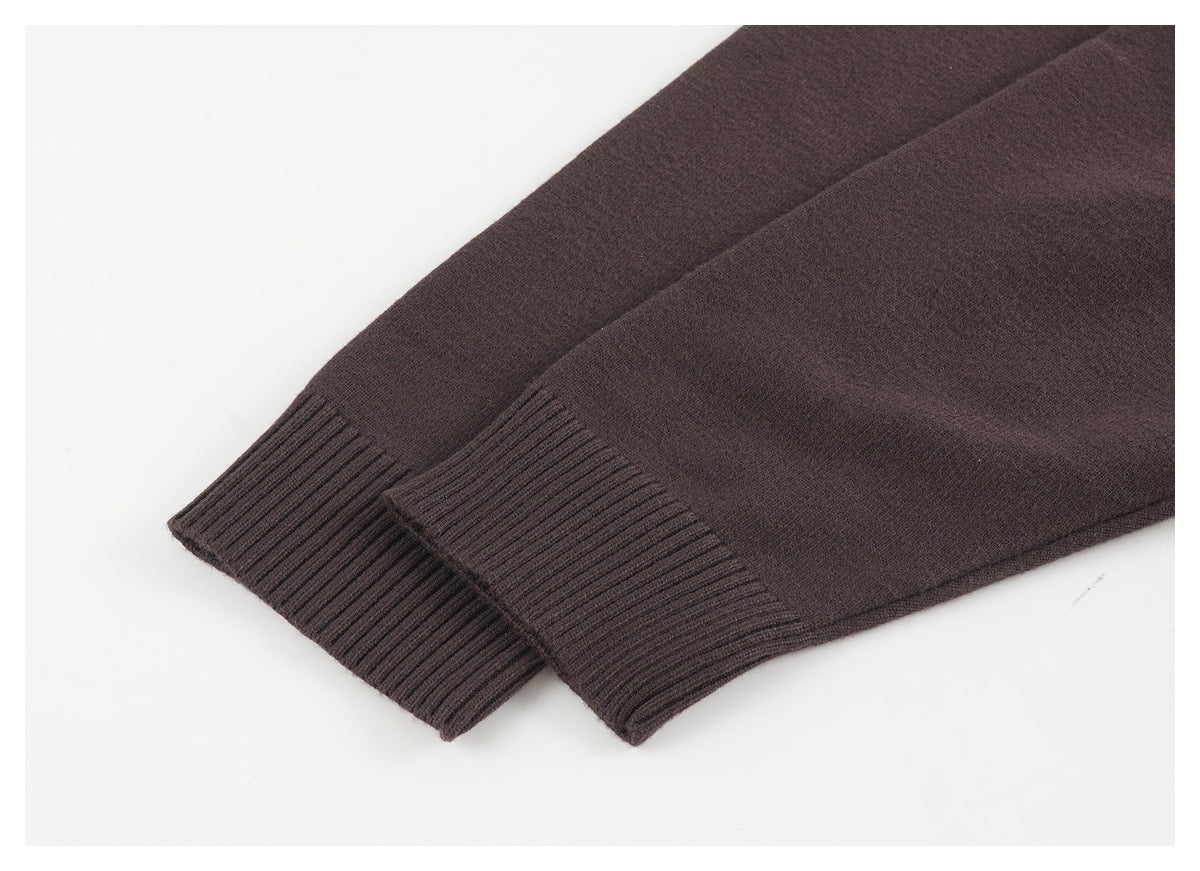 Dark brown sweater sleeves laid flat, showing ribbed cuffs.