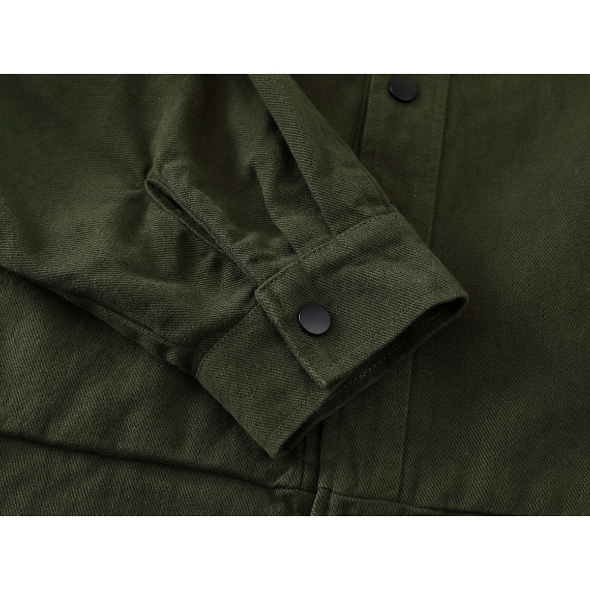 Close-up of an olive green jacket sleeve and snap-button cuff beside the front placket.